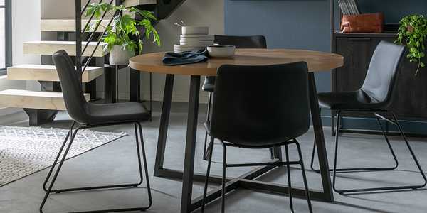 Metal dining table with 3 black dining chairs.